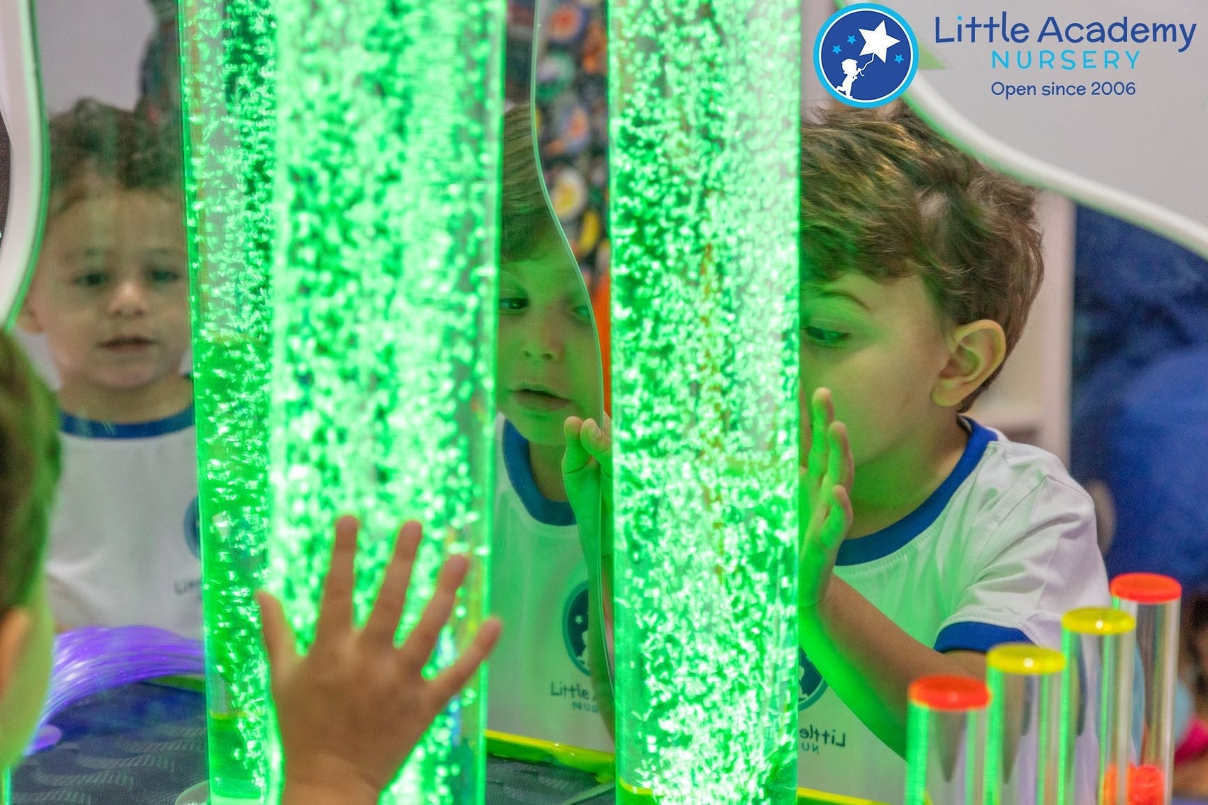 A group of students are doing activity in a sensory room. They are touching a sensory play device.